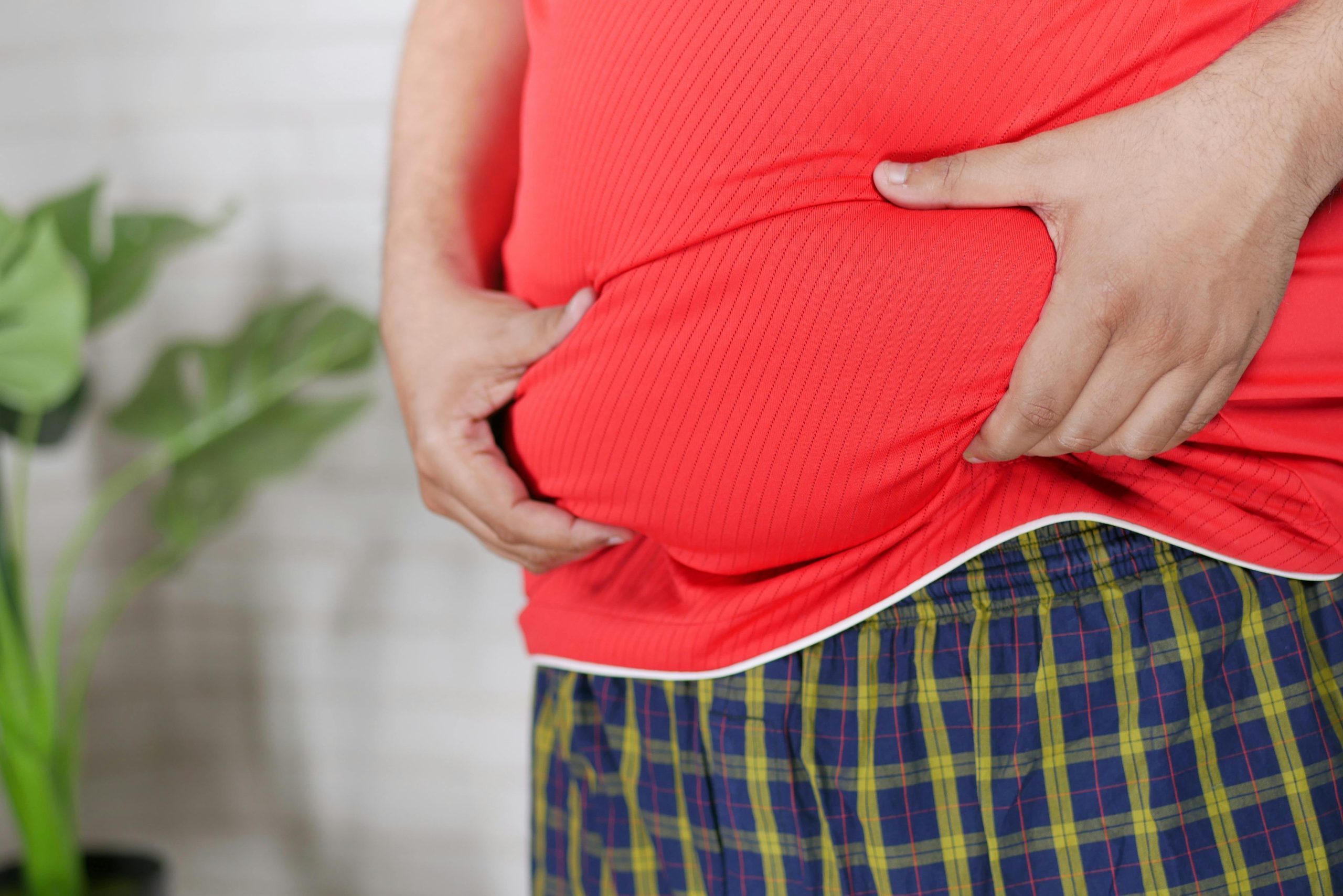 Overweight man holding their belly