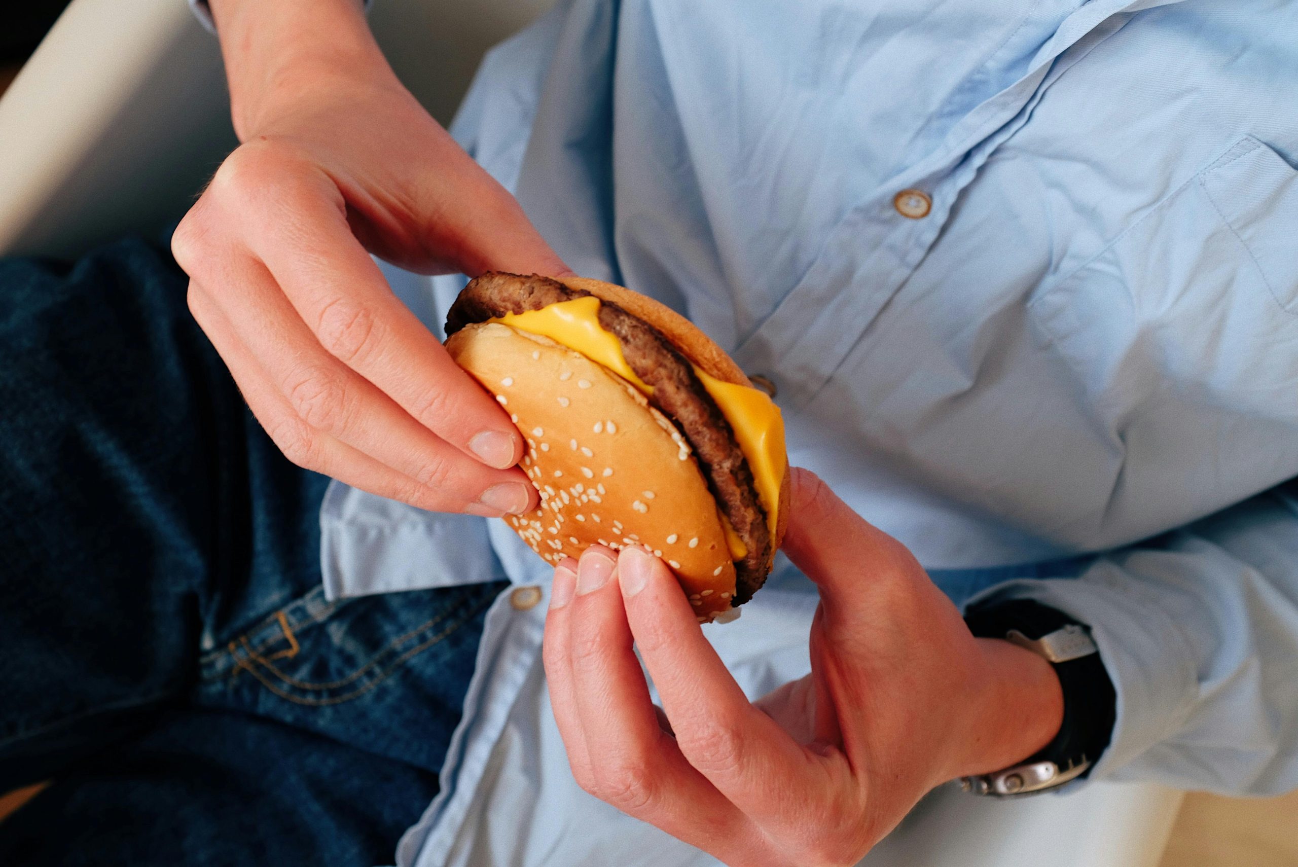 Person holding a cheeseburger